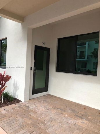 Front view of a building entrance with a glass door and a window.