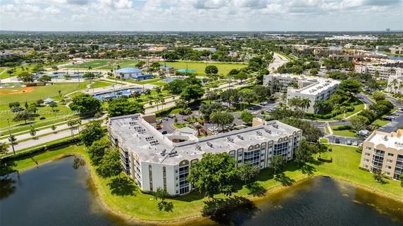 Aerial view of residential buildings with nearby recreational facilities and greenery.