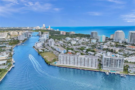 Panoramic view of a coastal cityscape with high-rise buildings and water channel.