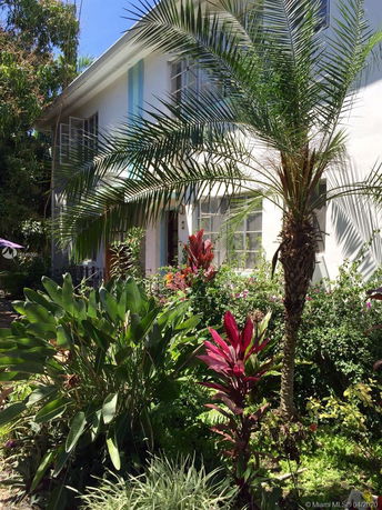 Front view of a two-story house with a garden.