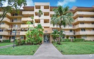 Front view of a multi-story apartment building with balconies.