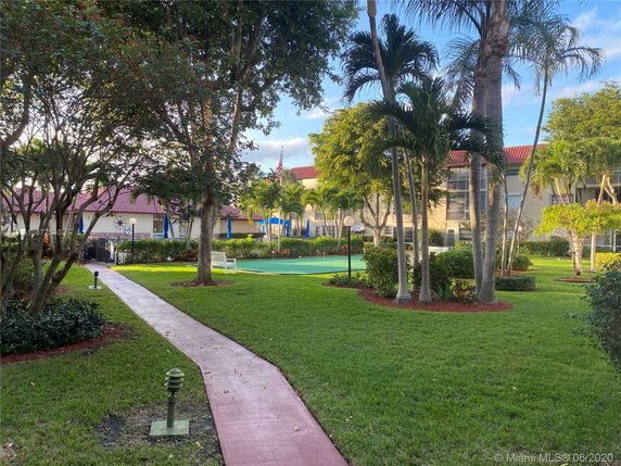 Outdoor recreational area surrounded by trees and a pathway.