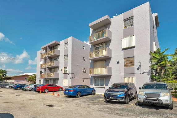 Outdoor parking area in front of a multi-story residential building.