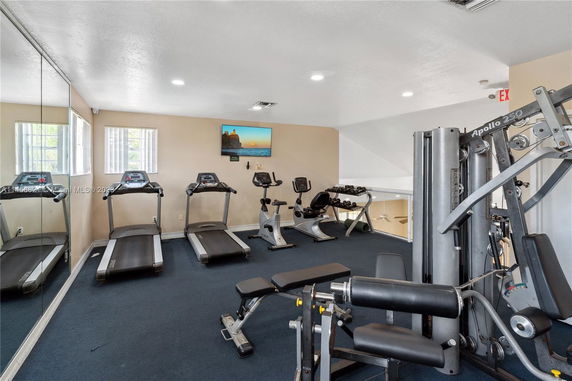 Indoor gym area with exercise machines including treadmills, stationary bikes, and weight equipment.
