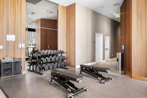 Interior view of a gym area with weights and benches.