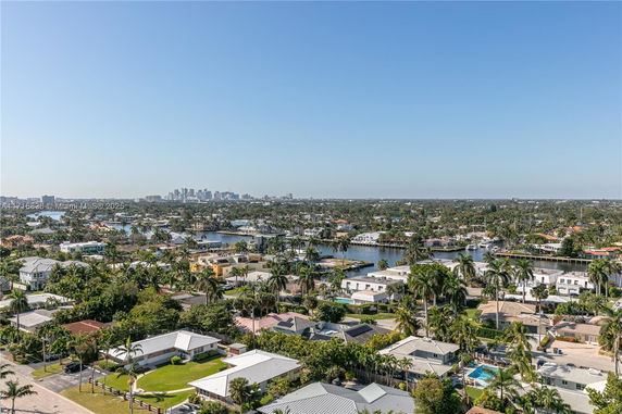Panoramic view of a residential area with waterways and distant city skyline.