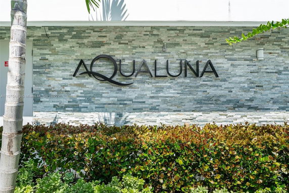Front view of a building with a textured stone facade displaying the name AQUALUNA.