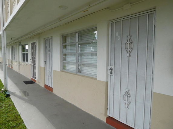 Front view of a building with metal security doors and windows.
