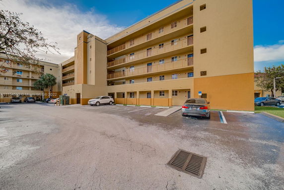 Outdoor parking area in front of a multi-story apartment building.