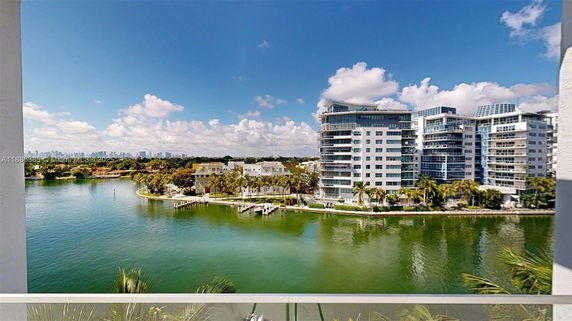 Panoramic view from a balcony showing waterfront and high-rise buildings.