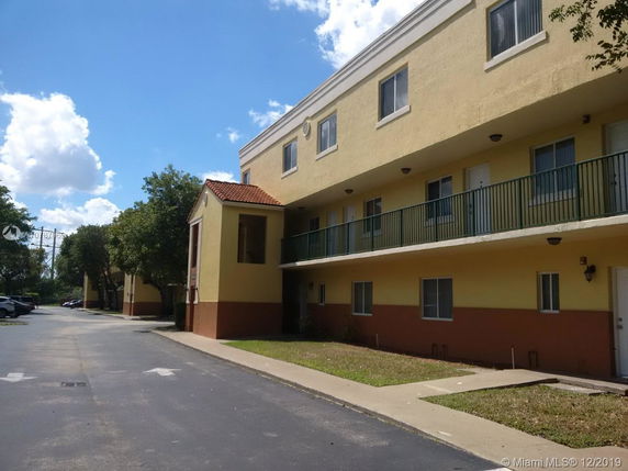 Front view of a three-story apartment building with balconies.
