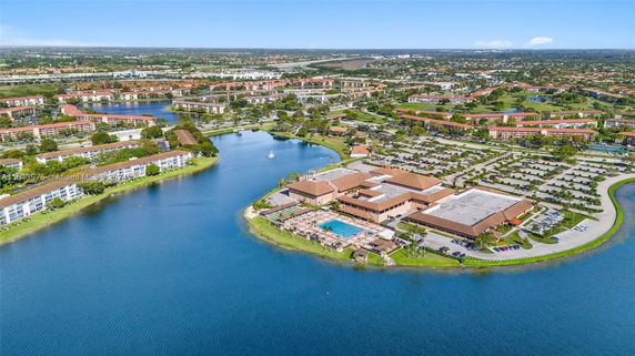 Aerial panoramic view of a residential area with a lake and surrounding buildings.
