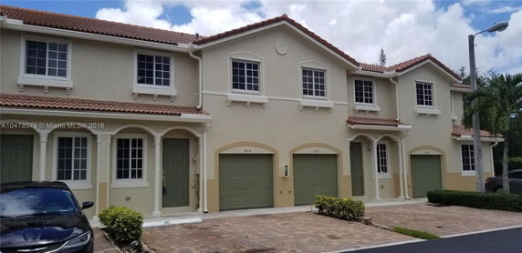 Front view of a multi-story townhouse with garages.