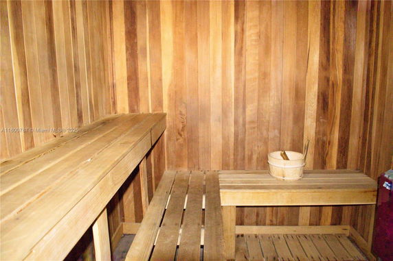 Interior of a wooden sauna room with benches and a wooden bucket.