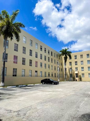 Outdoor parking area in front of a multi-story building.