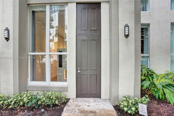 Front view of a house with a tall entry door and adjacent windows.