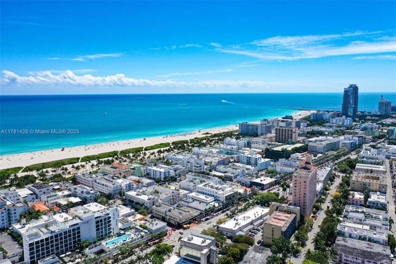 Panoramic aerial view of a coastal city with buildings and beachfront.