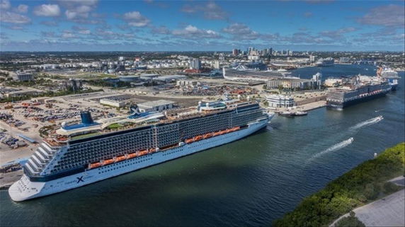 Aerial panoramic view of a coastal area with cruise ships docked at a port.