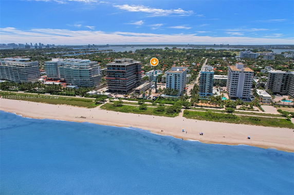 Panoramic view of beachfront buildings with ocean in the foreground.