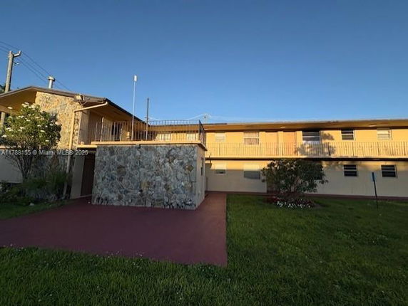 Front view of a two-story building with a stone exterior and balcony.