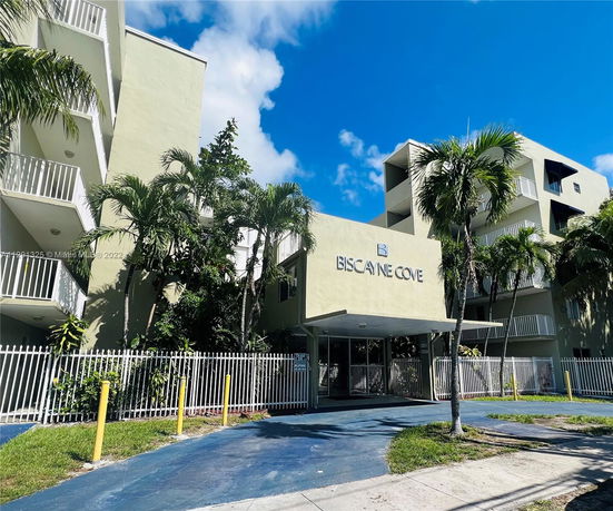 Front view of a multi-story building named Biscayne Cove with balconies.