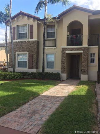 Front view of a two-story house with stone and stucco exterior.