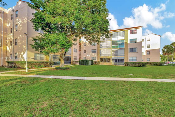 Front view of a multi-story residential building with large windows.