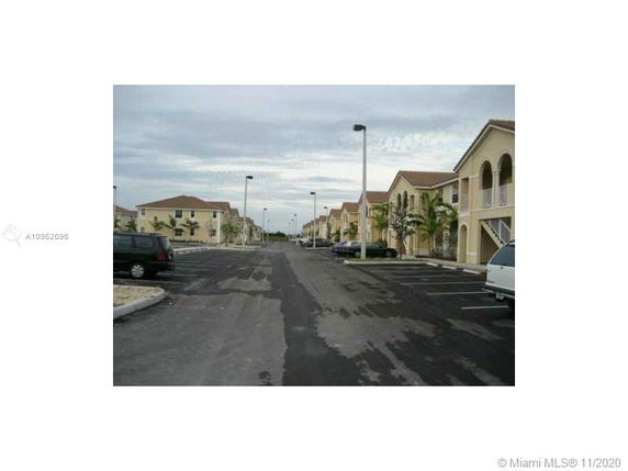 Outdoor parking area in a residential complex with multiple buildings.