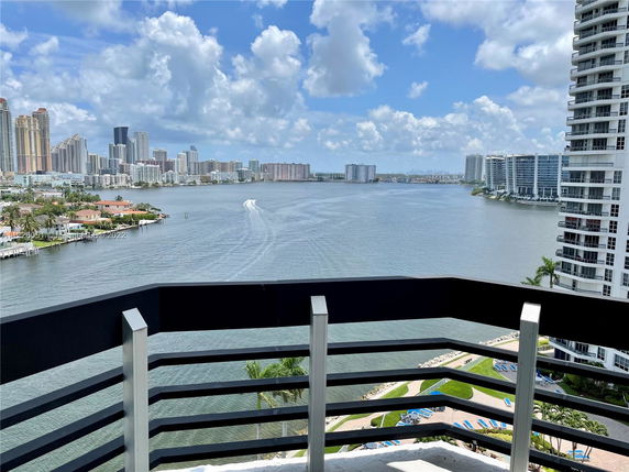 Panoramic view of a cityscape across a body of water from a balcony.