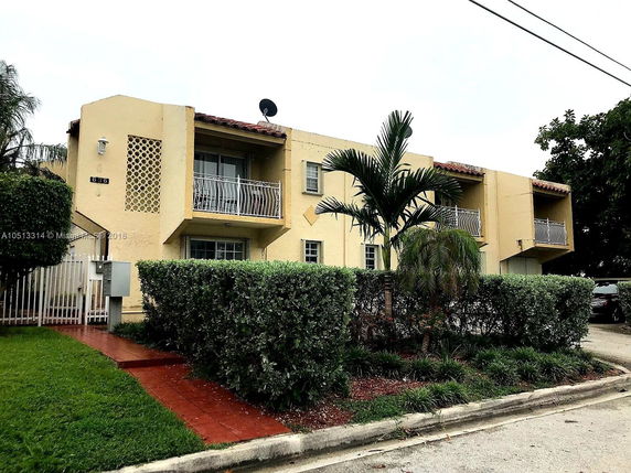 Front view of a two-story building with balconies and a garden path.