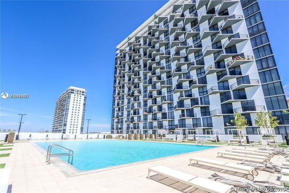 Outdoor swimming pool next to a modern high-rise building.