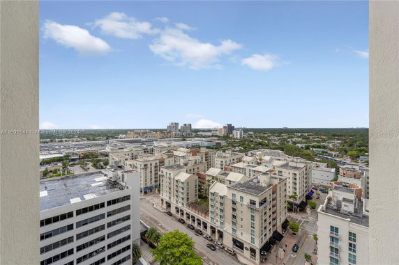 Wide-angle view of cityscape with multiple buildings and a sprawling landscape.
