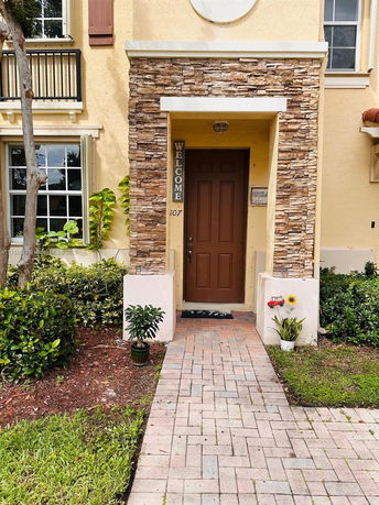 Front view of a multi-story house with a stone entrance and wooden door.