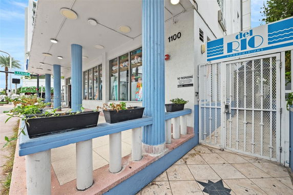 Front view of a building with blue columns and a gated entrance.