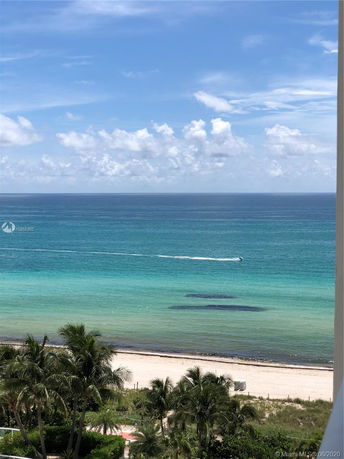 Wide angle view of ocean and beach with clear skies.
