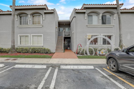 Front view of a two-story residential building with parking spaces.