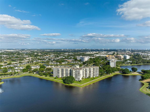 Panoramic view of a coastal cityscape with multi-story buildings by a large body of water.