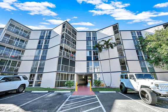 Front view of a multi-story apartment building with balconies.