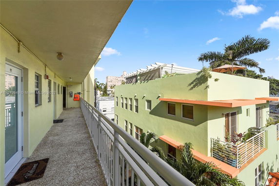 View from a walkway on a building looking towards another building with balconies.