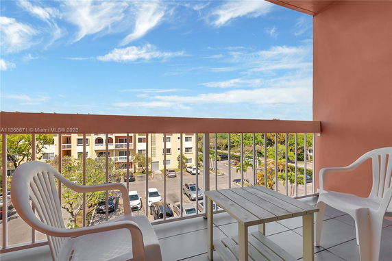 Balcony view overlooking a parking area and residential buildings.
