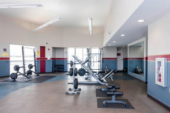 Indoor gym area with exercise equipment and mirrors.