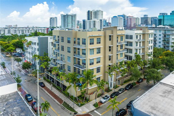Elevated view of a multi-story apartment building with balconies and large windows.