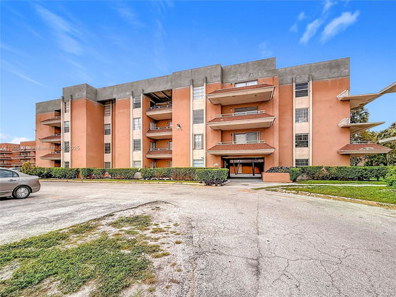 Front view of a multi-story apartment building with balconies.