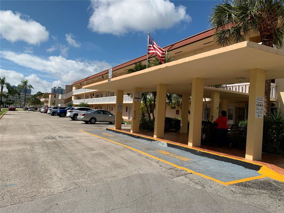 Front view of a two-story building with an entryway and parking area.