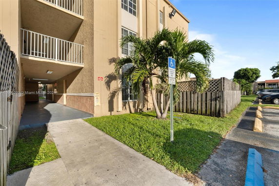 Front view of a multi-story building with balconies and a covered walkway.