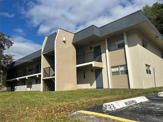 Front view of a two-story building with a flat roof and balconies.