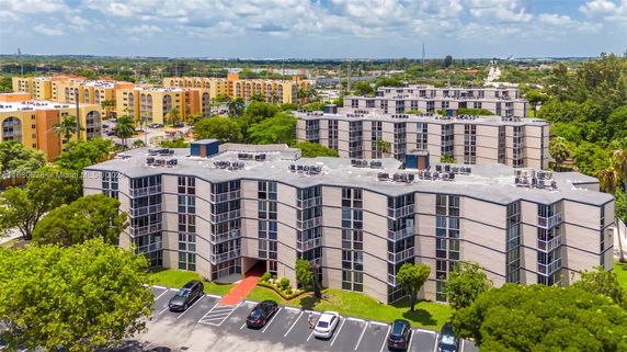 Aerial view of multi-story apartment buildings with flat rooftops featuring multiple air conditioning units.