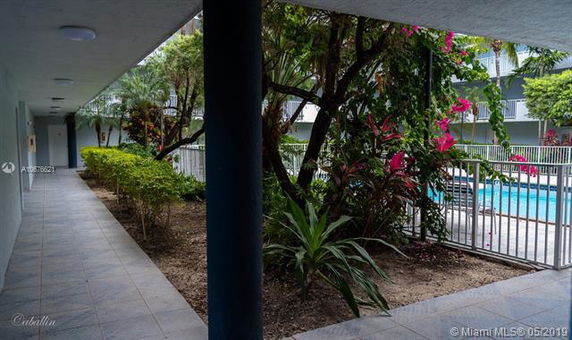 Outdoor pool area next to a garden walkway.