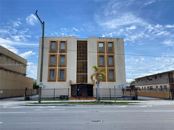 Front view of a four-story building with gated entrance.