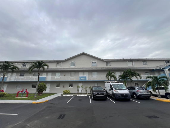 Front view of a multi-story building with parking area.